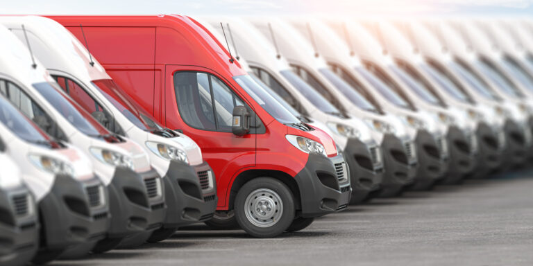 Red delivery van in a row of white vans. Best express delivery a